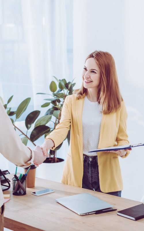 happy-recruiter-holding-clipboard-and-shaking-hands-with-employee-in-modern-office.jpg happy-recruiter-holding-clipboard-and-shaking-hands-with-employee-in-modern-office.jpg